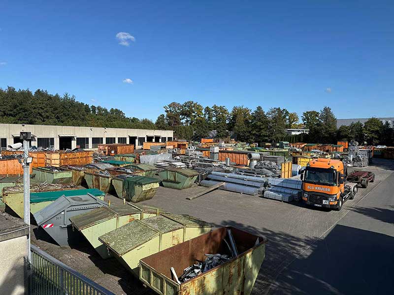 Blick über das Betriebsgelände von Aluminium Krüger mit Containern, Metallteilen und einem LKW