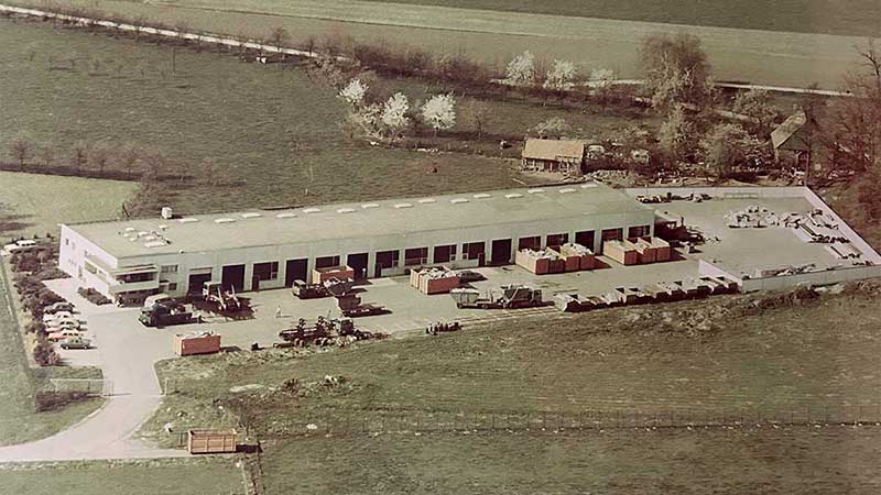 Historische Luftaufnahme des Aluminium Krüger Firmengeländes mit Lagerflächen, Fahrzeugen und Containern in ländlicher Umgebung.