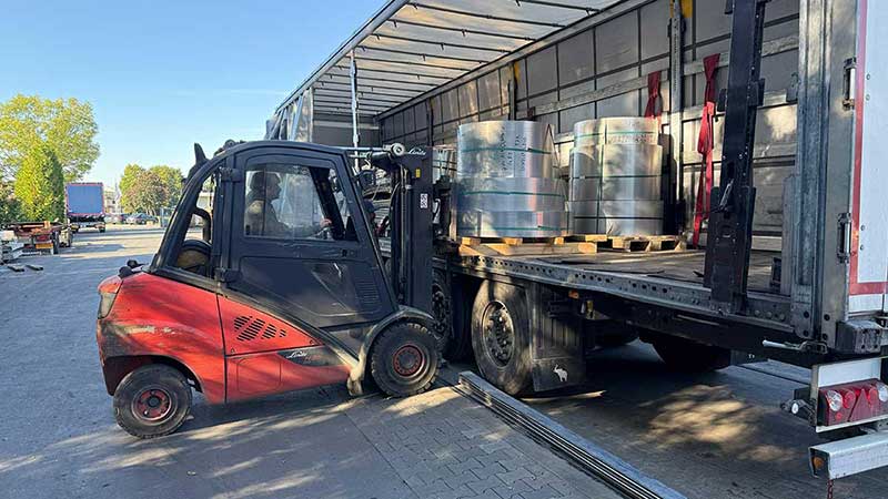 Gabelstapler lädt Aluminiumrollen auf einen LKW-Anhänger auf dem Betriebsgelände von Aluminium Krüger
