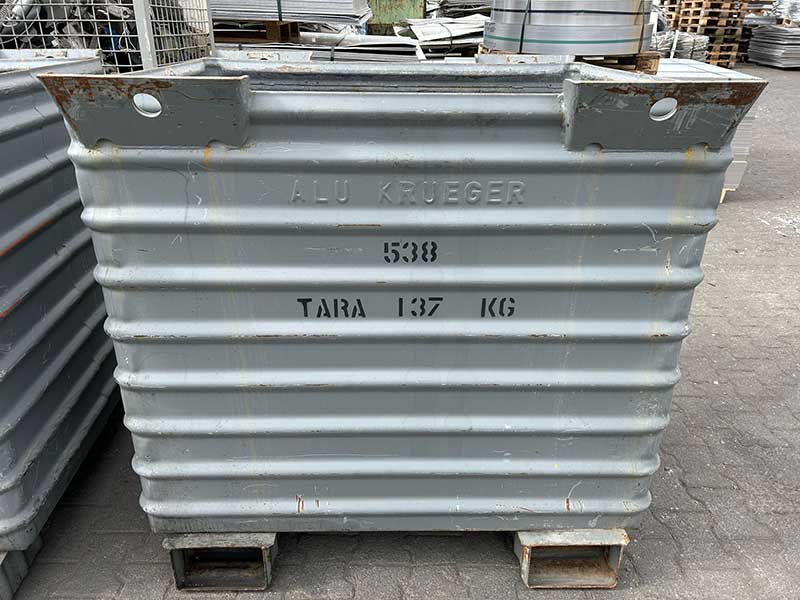 Grauer Schüttbehälter mit der Aufschrift „ALU KRUEGER“ und Gewichtsangabe, verwendet zur Lagerung und zum Transport von Aluminiumschrott